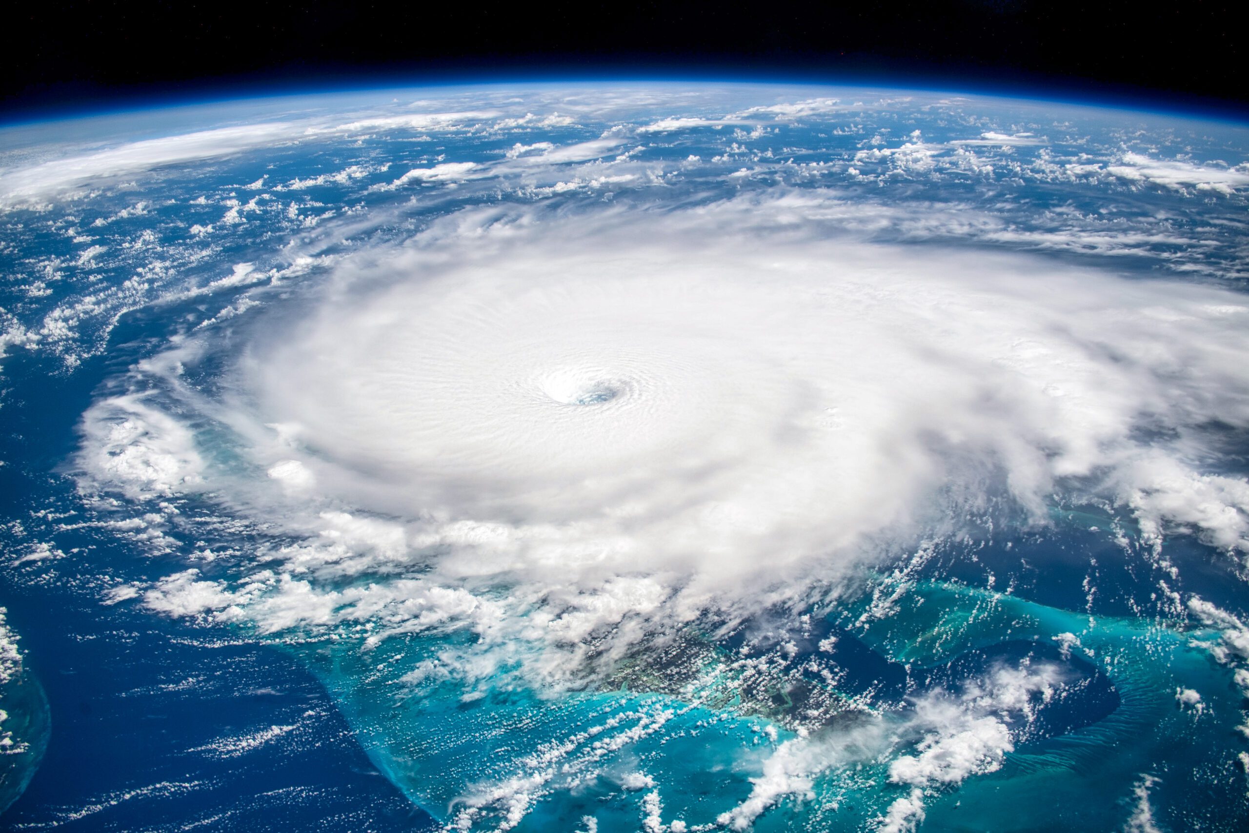 View of a swirling hurricane cloud formation above Earth as seen from space.