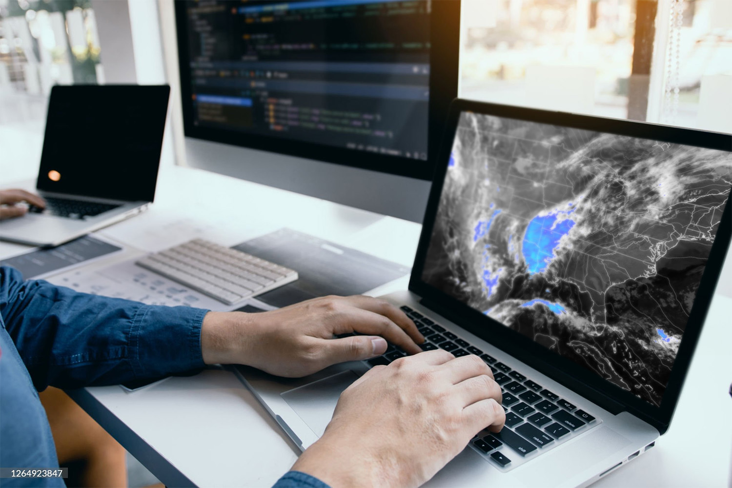 Person typing on laptop with a map visual on screen